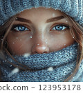 Close-up of a woman wearing a knit scarf and hat surrounded by snowflakes. Winter fashion and seasonal concept 123953178