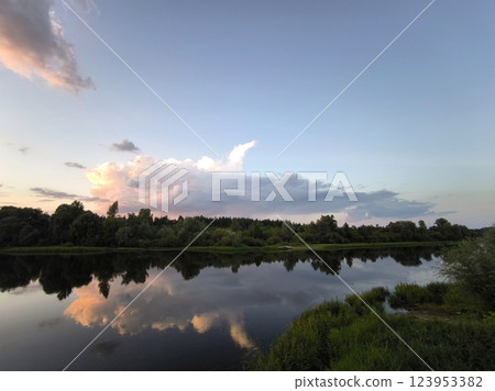 Beautiful sunset over the river with pink clouds. Atmospheric summer sunset over the water 123953382
