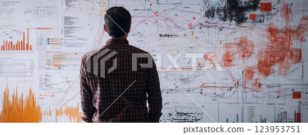 Professional analyzing complex data and charts on a whiteboard in a collaborative work environment 123953751