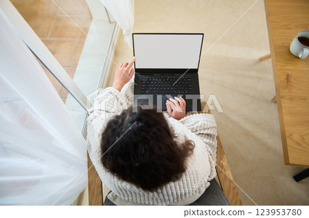 Cozy Freelancer Working Remotely on Business Plan with Laptop and Coffee 123953780