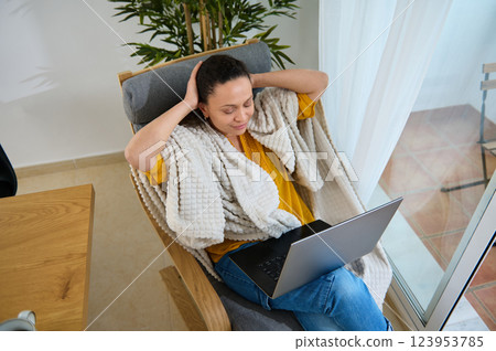 Young Woman Remote Working with Laptop in Cozy Home Environment Young Woman Remote Working with Laptop in Cozy Home Environment 123953785