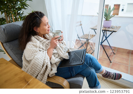 Freelancer Working Comfortably from Home with Laptop and Coffee Freelancer Working Comfortably from Home with Laptop and Coffee 123953791