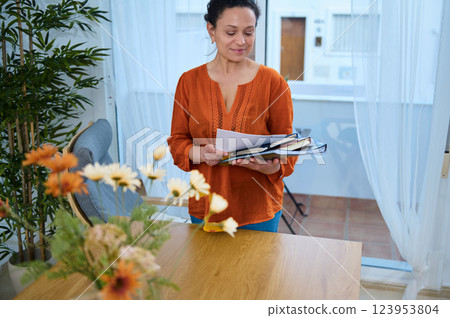 Young Woman Planning a Creative Project while Working Remotely at a Cozy Home Young Woman Planning a Creative Project while Working Remotely at a Cozy Home 123953804