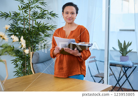 Young Woman Remote Working at Home with Business Documents in Creative Space Young Woman Remote Working at Home with Business Documents in Creative Space 123953805