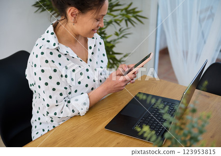 Young Woman Working Remotely With Laptop and Smartphone at Home 123953815