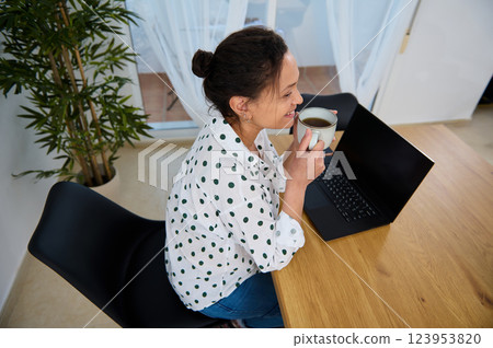 Smiling Freelancer Enjoying Remote Work at Home with Coffee and Laptop Smiling Freelancer Enjoying Remote Work at Home with Coffee and Laptop 123953820