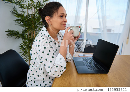 Young Woman Warming Up with Coffee While Working Remotely from Home 123953821