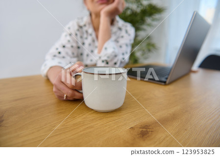 Cozy Remote Work Setting Featuring Laptop and Coffee Mug on Wooden Table Cozy Remote Work Setting Featuring Laptop and Coffee Mug on Wooden Table 123953825