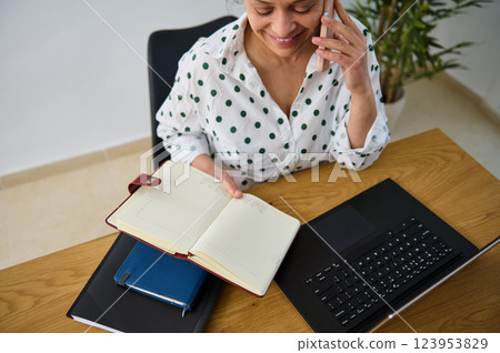 Smiling Woman Working Remotely with Planner and Laptop Smiling Woman Working Remotely with Planner and Laptop 123953829