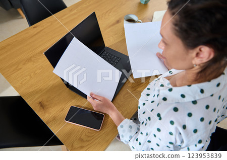 Young Woman Working Remotely from Home Reviewing Documents 123953839