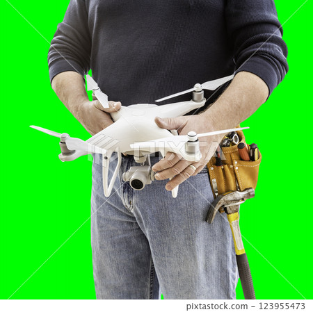Partial View of Construction Worker Wearing Toolbelt and Holding His UAV Drone on Green Screen. 123955473