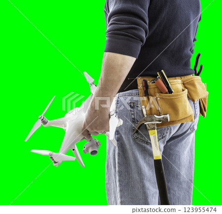 Partial View of Construction Worker Wearing Toolbelt and Holding His UAV Drone on Green Screen. Partial View of Construction Worker Wearing Toolbelt and Holding His UAV Drone on Green Screen. 123955474