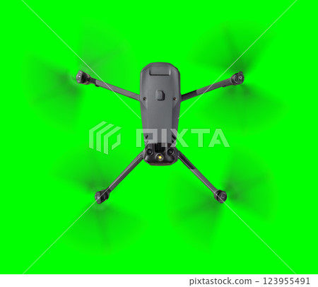 Isolated Top View of an Unmanned Aircraft System (UAV) Quadcopter Drone In The Air Over A Green Screen. 123955491