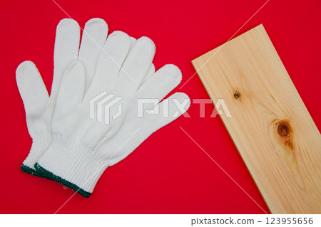 Work gloves on a wooden board on a red background 123955656