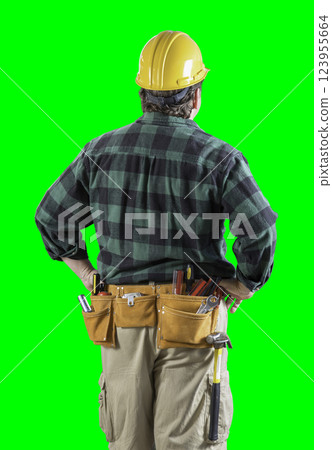 Rear View of Construction Worker Wearing Tool Belt and Holding Hard Hat on Green Screen. 123955664