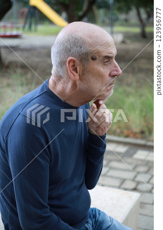 Pensive Elderly Man Sitting In Natural Park Reflecting On The Past Pensive Elderly Man Sitting In Natural Park Reflecting On The Past 123956777