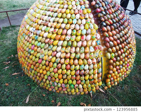 The vibrant collection of hand-painted eggs creates a lively atmosphere during a spring festival. Attendees admire the artistic designs on the eggs while enjoying the festive spirit. 123956885