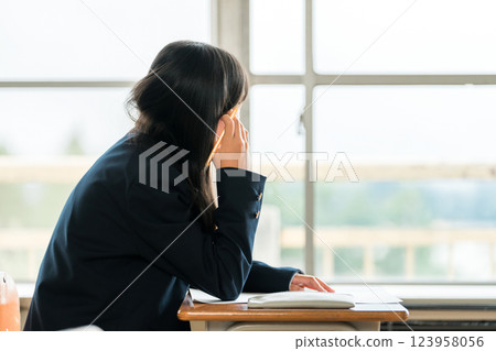 A female junior high school student looking outside during class (career path, dreams, adolescence) A female junior high school student looking outside during class (career path, dreams, adolescence) 123958056