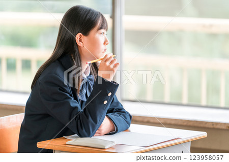 A female junior high school student looking outside during class (career path, dreams, adolescence) A female junior high school student looking outside during class (career path, dreams, adolescence) 123958057