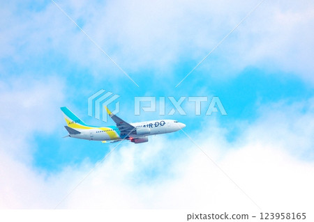 Passenger plane flying in blue sky and white clouds 1 123958165