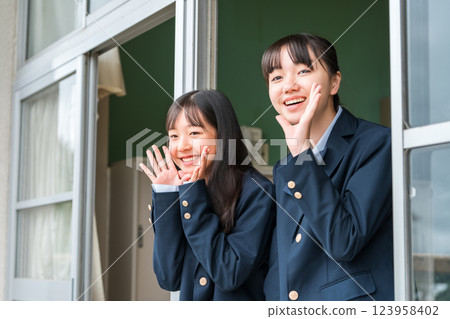 Junior and senior high school girls cheering from the classroom windows Junior and senior high school girls cheering from the classroom windows 123958402