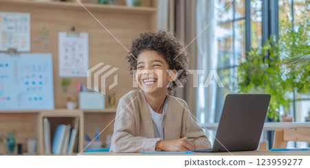 Happy child learning math on laptop in bright, minimalistic room Happy child learning math on laptop in bright, minimalistic room 123959277
