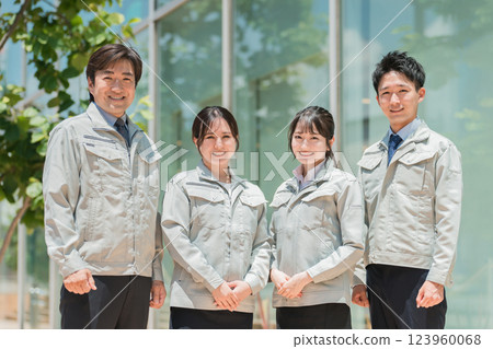Male and female staff in the manufacturing, building, transportation, and construction industries wearing work clothes. 123960068