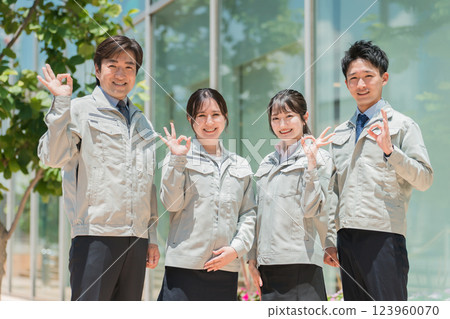 Male and female staff in the manufacturing, building, transportation, and construction industries wearing work clothes. 123960070