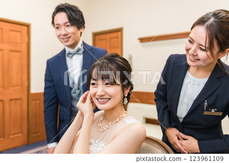一位新娘和一位策劃女士在新娘房/候診室準備婚禮/招待會 123961109