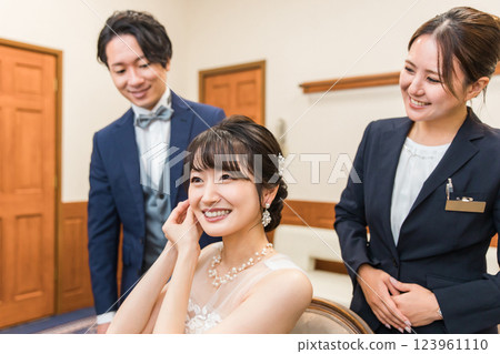 A bride and a planner woman preparing for a wedding ceremony / reception in a bride's room / waiting room A bride and a planner woman preparing for a wedding ceremony / reception in a bride's room / waiting room 123961110