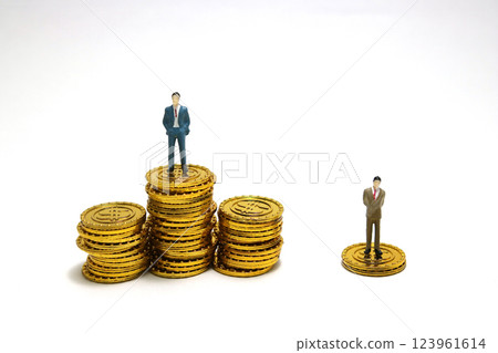 Income inequality and business success - miniature of businessman on gold coins Income inequality and business success - miniature of businessman on gold coins 123961614