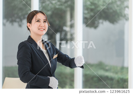 Wedding planner, bridesmaid, attendant, hotelier woman looking at watch at wedding hall/hotel 123961625