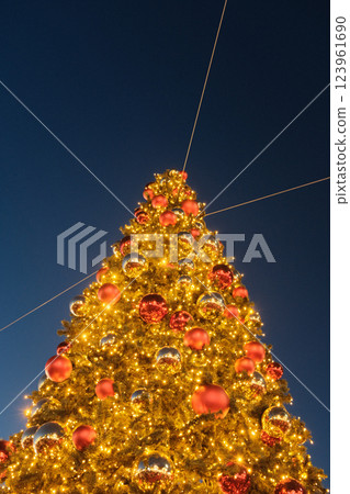 Golden Christmas tree adorned with glowing lights and ornaments in a festive evening setting. High quality photo Golden Christmas tree adorned with glowing lights and ornaments in a festive evening setting. High quality photo 123961690