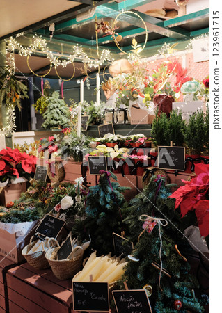 Holiday market stalls showcasing festive floral arrangements, Christmas greenery, and seasonal decorations. High quality photo 123961715