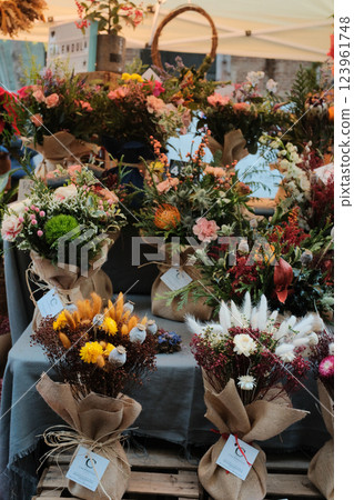 Holiday market stalls showcasing festive floral arrangements, Christmas greenery, and seasonal decorations. High quality photo 123961748