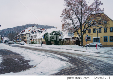 A picturesque snowy road gracefully winding through a charming little village during the magical winter season 123961791