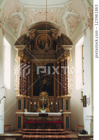 Scenic view of a charming lakeside village featuring a historic church, surrounded by majestic mountains. Tourists enjoy the tranquil atmosphere and beautiful architecture in Konigsse lake Bavaria 123961863