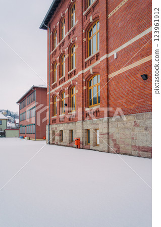 A picturesque snowy road gracefully winding through a charming little village during the magical winter season A picturesque snowy road gracefully winding through a charming little village during the magical winter season 123961912