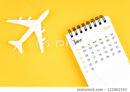 June 2025 calendar and airplane toy on yellow background. June 2025 calendar and airplane toy on yellow background. 123962343