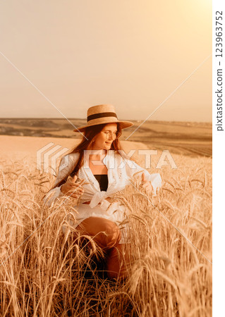 Woman Wheat Field Summer: Golden hour portrait, serene woman sits amidst ripe wheat, enjoying summer's warmth. Woman Wheat Field Summer: Golden hour portrait, serene woman sits amidst ripe wheat, enjoying summer's warmth. 123963752