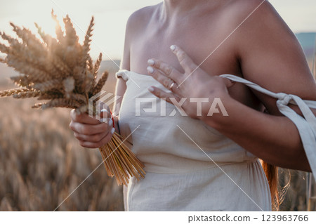 Woman in a White Dress Holding Wheat Stalks 123963766