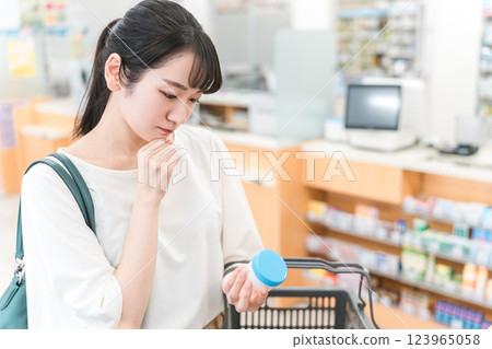 A woman shopping for ointments and steroids at a pharmacy, drug store, or convenience store 123965058
