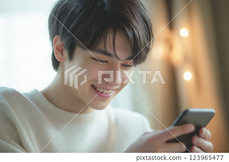 A young Asian man operating a smartphone "AI generated image" A young Asian man operating a smartphone "AI generated image" 123965477