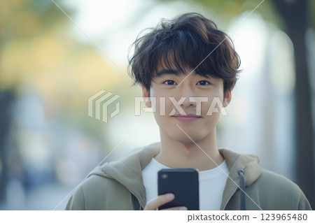 A young Asian man operating a smartphone "AI generated image" A young Asian man operating a smartphone "AI generated image" 123965480