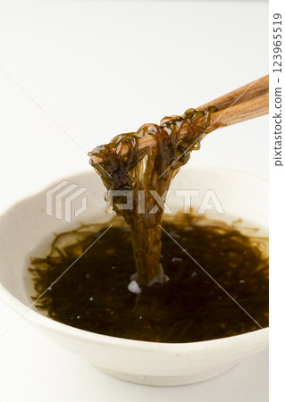 Pick up the vinegared mozuku seaweed with chopsticks Pick up the vinegared mozuku seaweed with chopsticks 123965519