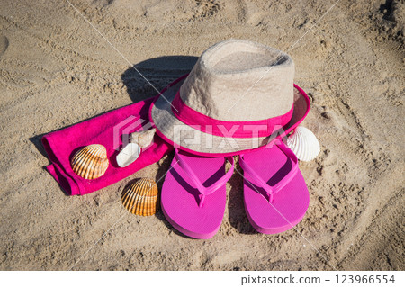 Accessories for relax on beach. Straw hat, flip flop and towel. Summertime 123966554