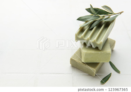 Olive soap bars forming a stack with olive branch on top Olive soap bars forming a stack with olive branch on top 123967365