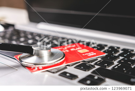 Stethoscope and credit card on the keyboard. Medical healthcare cost concept. Stethoscope and credit card on the keyboard. Medical healthcare cost concept. 123969071
