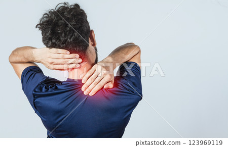 Close up of person with shoulder and neck problems, sore man touching his shoulder on isolated background, lumbar and muscular problems concept Close up of person with shoulder and neck problems, sore man touching his shoulder on isolated background, lumbar and muscular problems concept 123969119