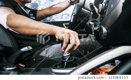 Close-up of driver hand on the gear lever of a car, concept of hand grabbing the gear lever of a car, close-up of hands accelerating on the gear lever Close-up of driver hand on the gear lever of a car, concept of hand grabbing the gear lever of a car, close-up of hands accelerating on the gear lever 123969133